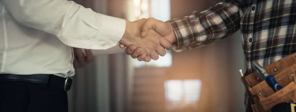 remodeling worker and contractor shaking hands with client