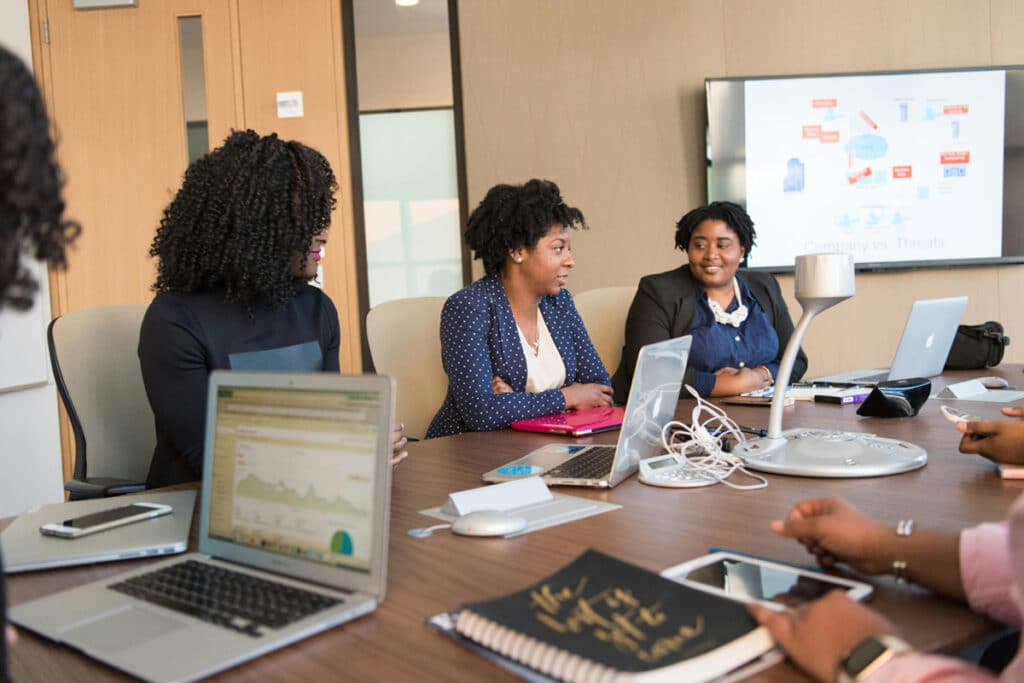 A small business team using a software dashboard on their laptops during a collaborative business meeting.